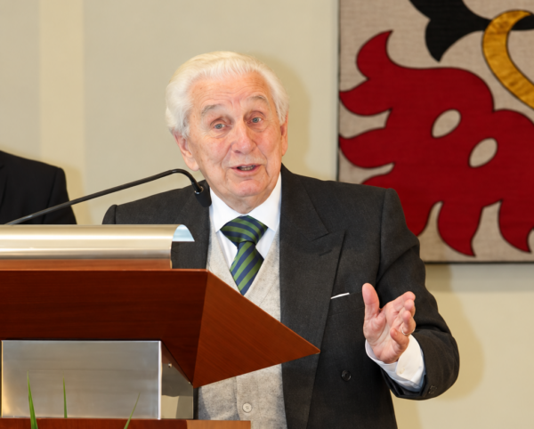 Discurso solemne junto a flores y estandarte